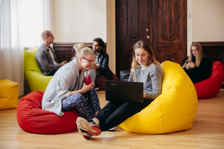 students relaxing on poof chairs, talking